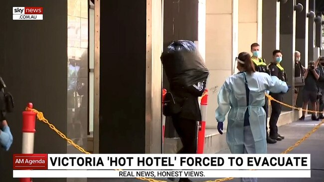 A guest being escorted out of Holiday Inn hotel with a garbage bag over their head.