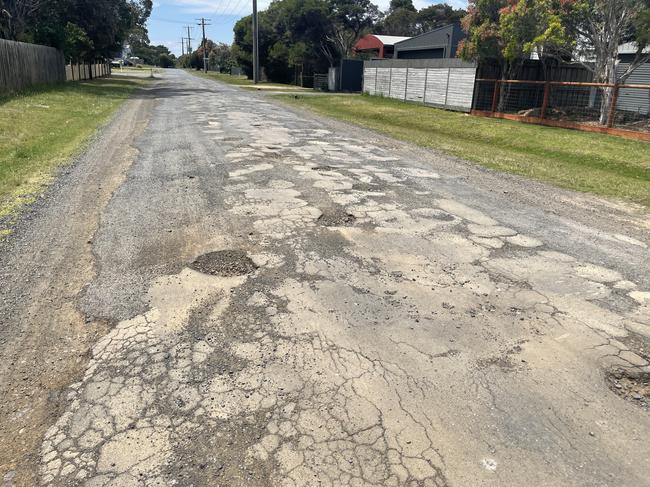 Motorists have to drive on the edge of the road and onto the grass to avoid hitting the potholes. Picture: Jack Colantuono