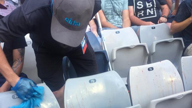 A worker cleans blood off the seats.