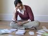 MONEYSAVERHQ .. Woman looking at bills and receipts on floor