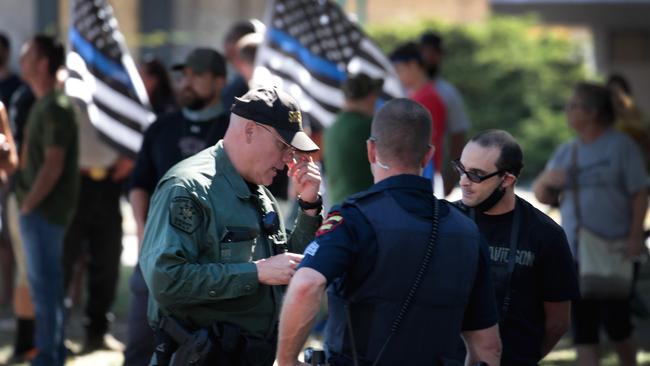 Police speak with a BLM organiser at a rally in front of the Kenosha County Courthouse. Picture: AFP.