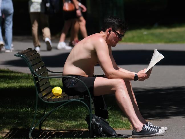 A shirtless man sits readign a newspaper in Sydney. Picture: NewsWire / Luis Enrique Ascui