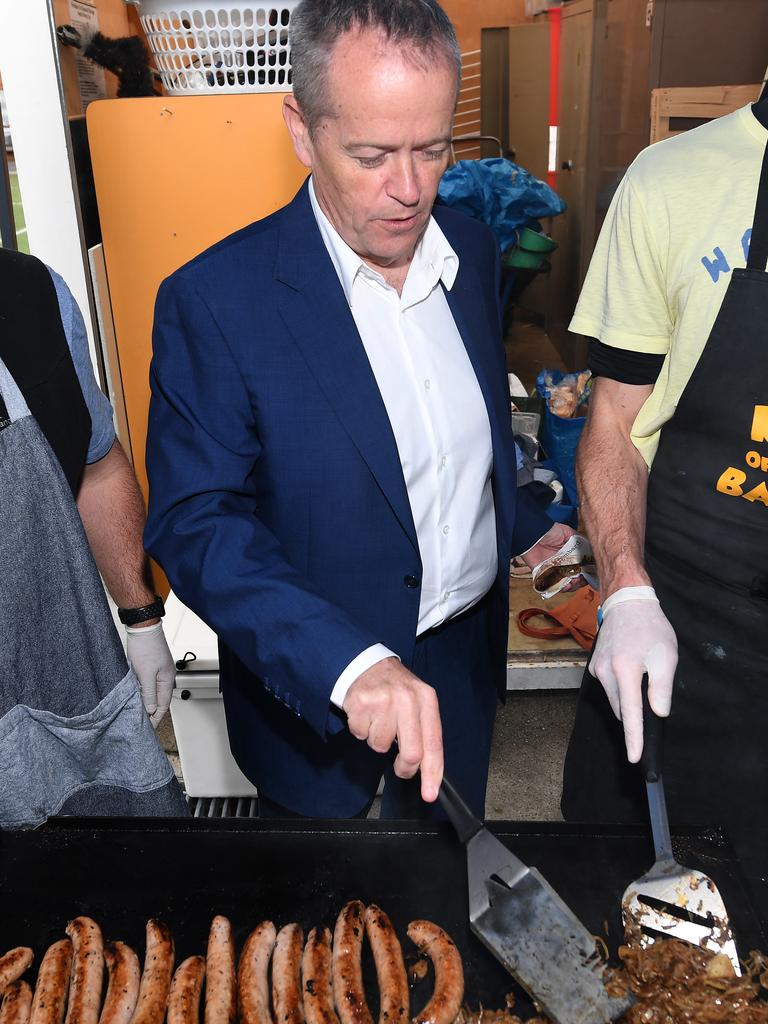 Bill Shorten turns sausages after voting on Saturday. Picture: Julian Smith.