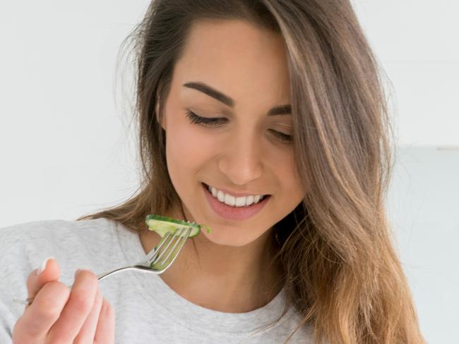 Healthy young woman dieting and eating a salad at home