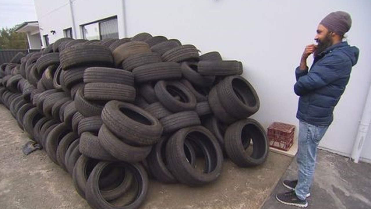 Mr Rai inspects the driveway stacked with hundreds of used tyres. Picture: 9 News