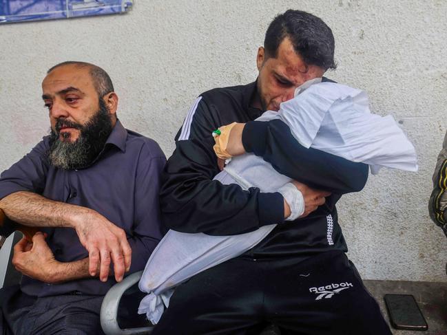 Palestinian father Ashraf cries as he holds the body of one of his two daughters after they were both killed in an overnight Israeli air strike in Rafah. Picture: Mohammed Abed/AFP