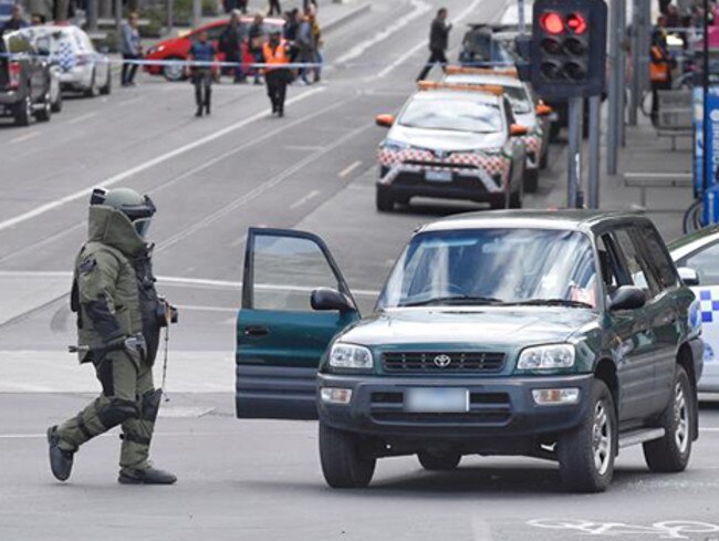 Police and bomb squad with sniffer dogs check over a car on flinders and swanston street, Melbourne CBD where earlier a man was making threats. Picture: Jason Edwards