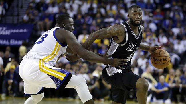 Jonathon Simmons drives past Draymond Green.