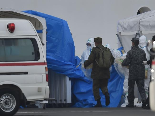 Military personnel and medical staff clad in protective gear are seen at work near the quarantined Diamond Princess cruise ship at Daikoku Pier Cruise Terminal in Yokohama. Picture: AFP