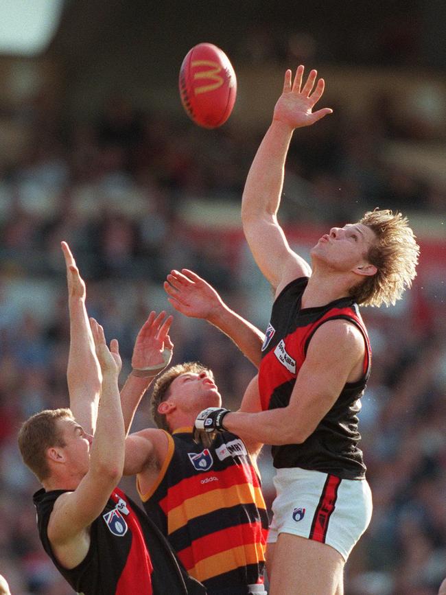 Barry Standfield, centre, playing for Adelaide against Essendon in 1997. Standfield started his career at Fish Creek.