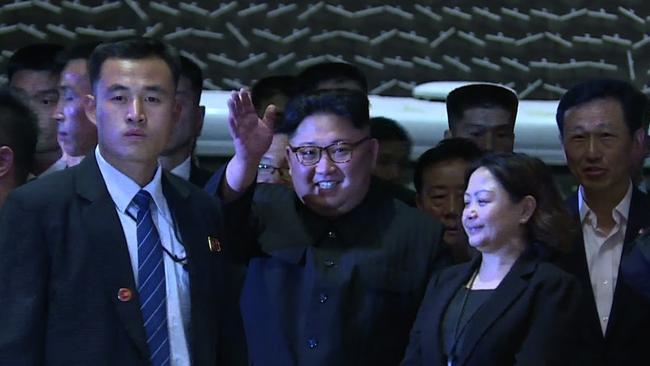 Kim Jong — un waves at the crowds as he arrives at the Sands Sky Park at the Marina Bay Sands Hotel. Picture: AFP.