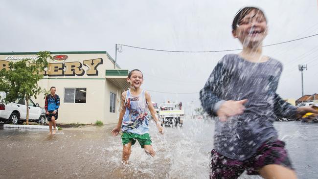 9 year old Cloncurry twins Paul and Tim Coffison run through floodwaters outside the Cloncurry Bakery after a deluge of much needed rain fell over drought stricken North West Queensland overnight. Photo Lachie Millard