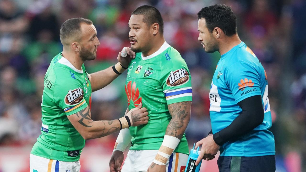 Joey Leilua is encouraged to leave the field by Josh Hodgson after copping a pyrotechnic shell in the eye.