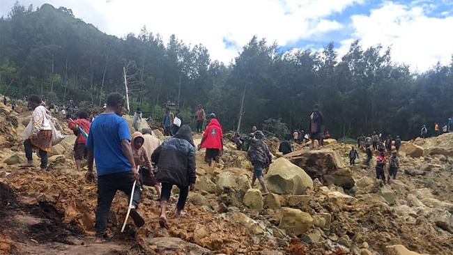 Locals walking on top of a landslide at Yambali Village in the region of Maip Mulitaka, in Papua New Guinea's Enga Province. Picture: AFP