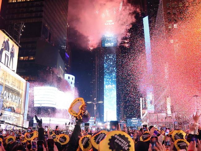 Onlookers watch as confetti fills the air to mark the beginning of the new year, in Times Square, New York City, on January 1, 2023. (Photo by Yuki IWAMURA / AFP)