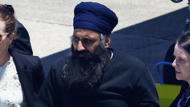 Queensland Police officers and detectives escort Rajwinder Singh from a chartered jet to a waiting police car at Cairns Airport after being extradited from New Delhi to Cairns via Melbourne. Picture: Brendan Radke