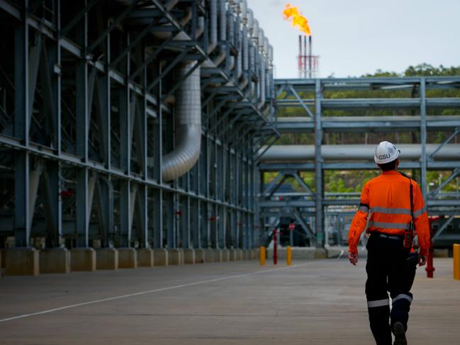 A worker walks through the Queensland Curtis Liquefied Natural Gas (QCLNG) project site, operated by QGC Pty, a unit of Royal Dutch Shell Plc, in Gladstone, Australia, on Wednesday, June 15, 2016. Gas from more than 2,500 wells travels hundreds of miles by pipeline to the project, where it's chilled and pumped into 10-story-high tanks before being loaded onto massive ships. Photographer: Patrick Hamilton/Bloomberg via Getty Images