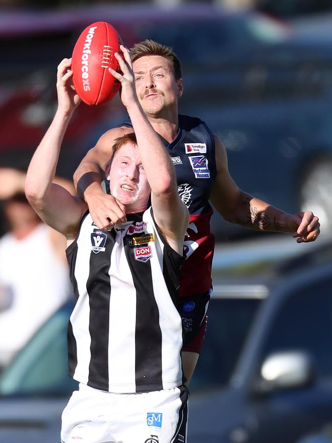 Sandhurst’s Fergus Greene launches over Castlemaine’s Brodie Byrne.