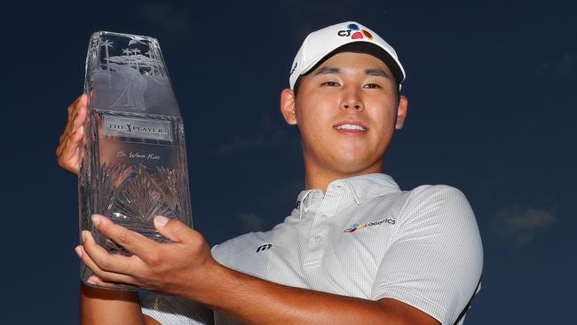 Si Woo Kim of South Korea celebrates with the Players Championship winner's trophy.