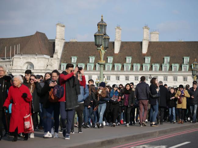 Members of the public walk along Westminster Bridge in central London on March 23, 2017 after it reopened following the March 22 terror attack at the British parliament. Picture: AFP