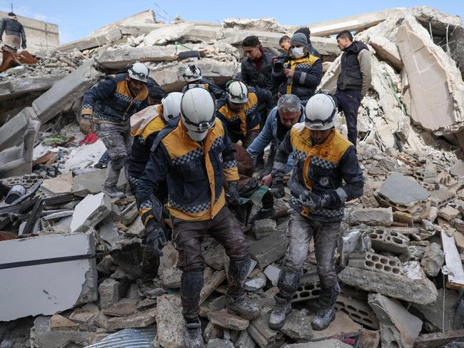 Members of the Syrian civil defence, known as the White Helmets, carry a victim from the rubble in Azmarin. Picture: AFP