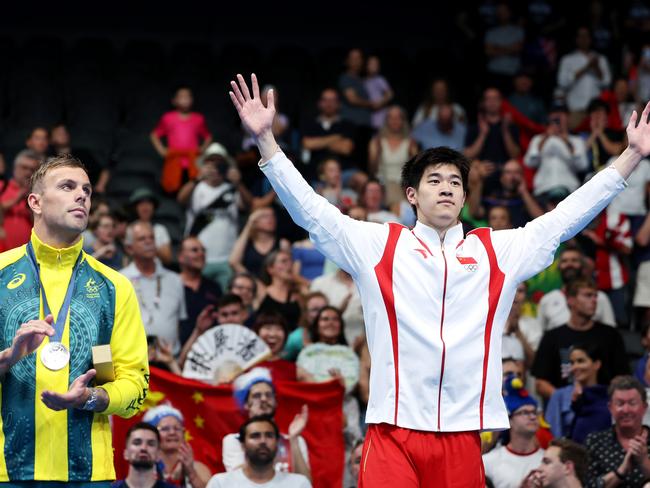 NANTERRE, FRANCE - JULY 31: Gold Medalist Zhanle Pan of Team People's Republic of China celebrates alongside Silver Medalist Kyle Chalmers of Team Australia on the podium during the Swimming medal ceremony after the Men's 100m Freestyle Final on day five of the Olympic Games Paris 2024 at Paris La Defense Arena on July 31, 2024 in Nanterre, France. (Photo by Quinn Rooney/Getty Images)