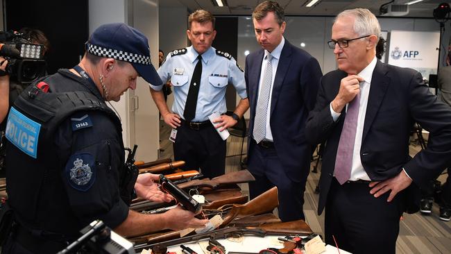 Australian Federal Police Commissioner Andrew Colvin, Justice Minister Michael Keenan and Prime Minister Malcolm Turnbull inspect firearms. Picture: AAP Image/Joel Carrett