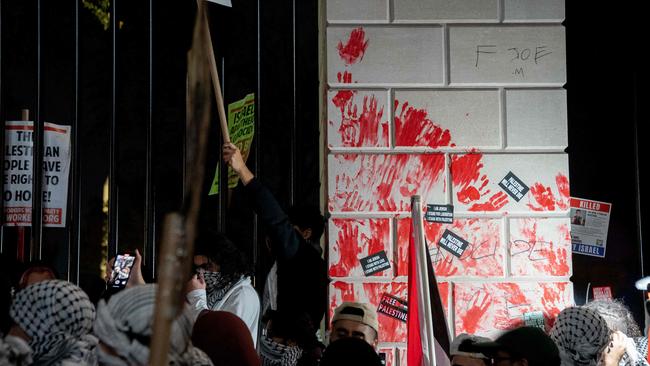 Demonstrators leave red hand prints on the fence in front of the White House during a rally in support of Palestinians in Washington, DC, on November 4. (Photo by Stefani Reynolds / AFP)