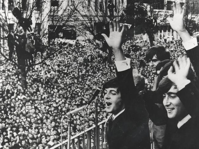 The Beatles wave to a huge crowd outside the Southern Cross Hotel in 1964.