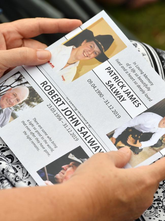 An attendee holds memorial cards during the funeral. Picture: Getty