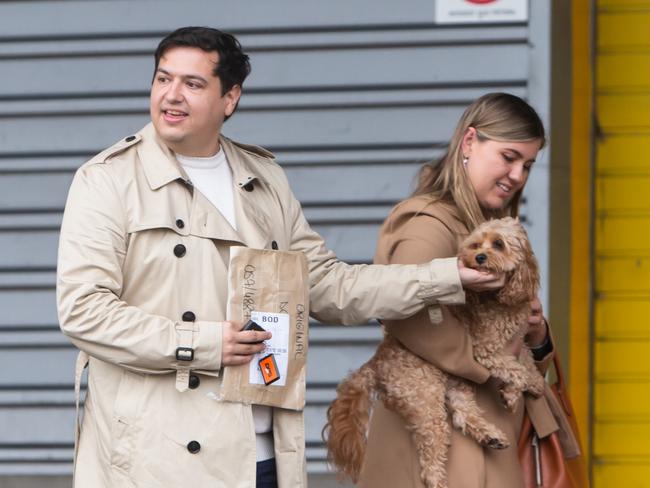 The couple appeared thrilled to be reunited with their beloved Cavoodle, Kingston. Picture: Matthieu Rondel