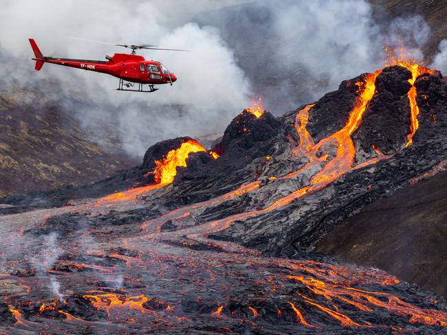 FAGRADALSFJALL, ICELAND - MARCH 20: (ICELAND OUT,  no archiving and no use after 26th March 2021) A helicopter flies close to a volcanic eruption which has begun in Fagradalsfjall near the capital Reykjavik on March 20, 2021 in Fagradalsfjall, Iceland. On Friday the Icelandic meteorological office announced a volcano, referring to a mountain located south-west of the Capital Reykjavik has erupted after thousands of small earthquakes in the area over the recent weeks. A no-fly zone has been established in the area. (Photo by Vilhelm Gunnarsson/Getty Images) Ã¢â¬â¹*** BESTPIX ***