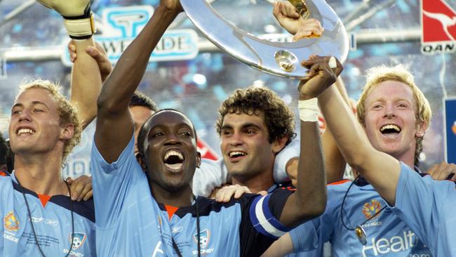 Dwight Yorke (centre) and teammates hold up the Grand Final trophy.