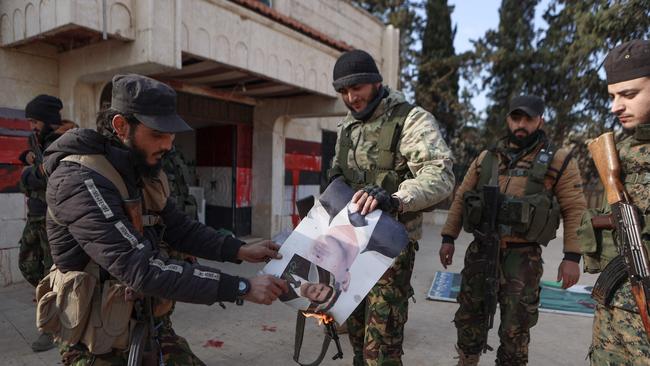 HTS dighters set alight a picture of Syrian President Bashar al-Assad in front of a building that was seized by jihadists in the area of Zarbah on November 29. Picture: Aaref Watad/AFP