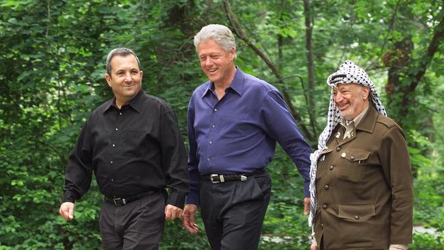 President Bill Clinton, Israeli Prime Minister Ehud Barak, left, and Palestinian leader Yasser Arafat, right, walk on the grounds of Camp David.