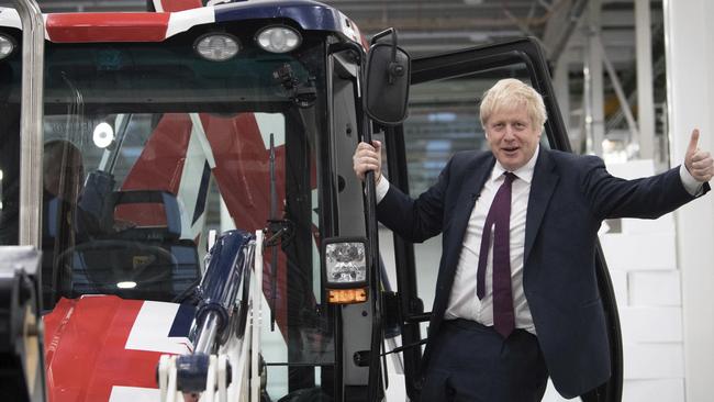 Boris Johnson drives a bulldozer through a foam wall at a JCB manufacturing facility in Uttoxeter. Picture; AP.