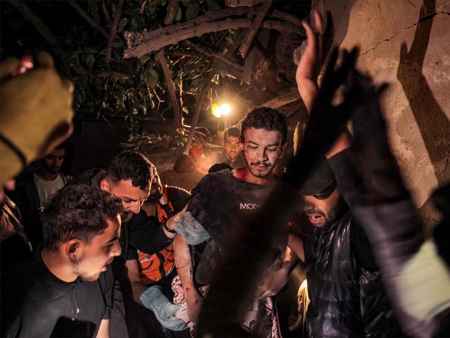 Palestinian civil defence and local residents evacuate a wounded man from the destroyed house which was struck by Israeli bombardment in Rafah.