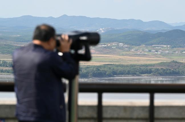 A man uses binoculars to look at the North Korean side of the Demilitarised Zone from South Korea's Odusan Unification Observatory in Paju