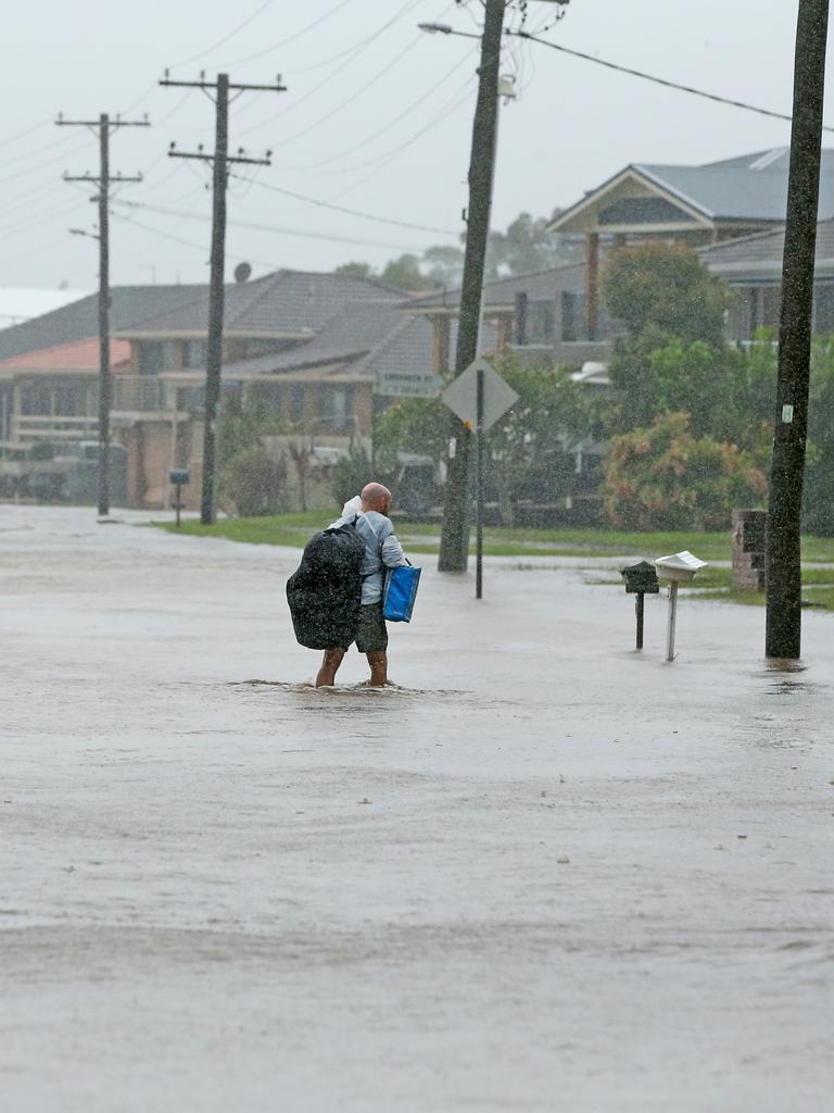 A resident tries to make his way back home in Port Macquarie. Picture: Nathan Edwards