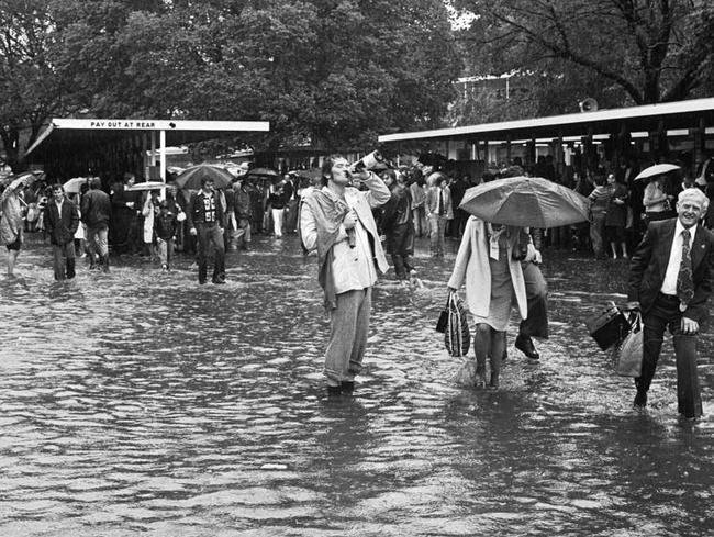 A punter finishes off his champagne despite the flooding at the Melbourne Cup in 1995. Picture: HWT Library.