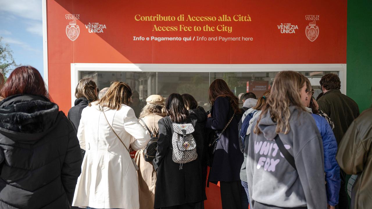 Tourists queue to buy entry tickets into Venice in April this year, when it was introduced for the first time. Picture: Marco Bertorello / AFP