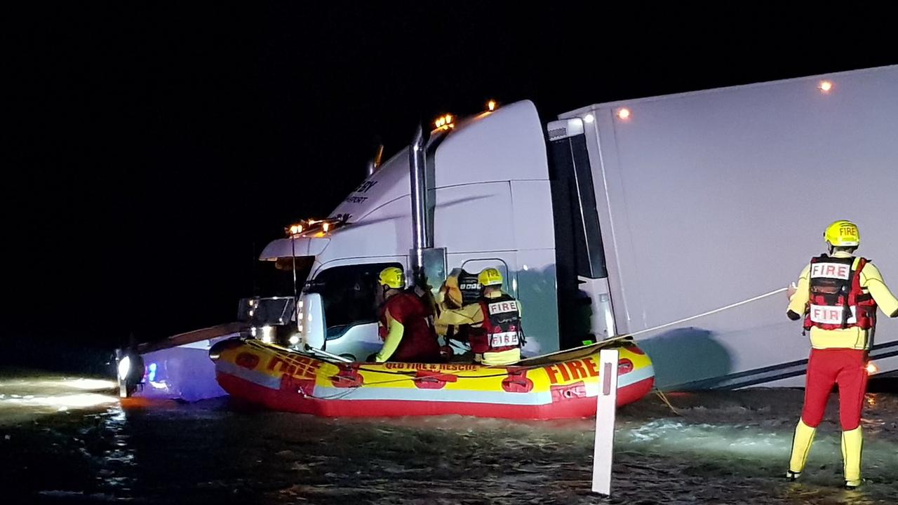 Queensland Fire and Emergency Services come to the aid of a truck driver trapped in floodwater outside Goondiwindi in the early hours of Tuesday, November 30.