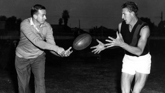 Essendon coach John Coleman does a little coaching in mufti with ruckman Brian Sampson in 1961.