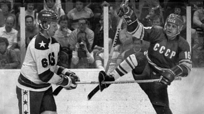 1980 : Bill Baker (L) attempts to retrieve his stick stuck through hole in skate of opponent Vladimir Petrov during USA v USSR match at 1980 Winter Olympic Games at Lake Placid.HistoricalIce Hockey