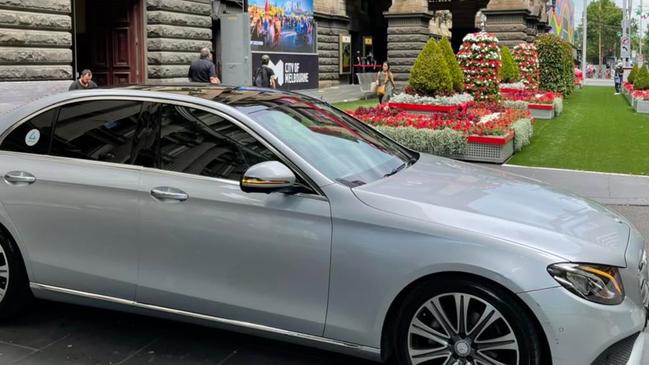 The chauffer-driven car on the footpath outside Town Hall.