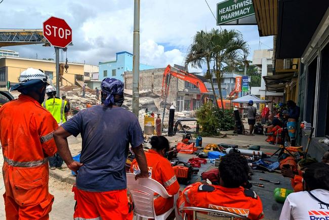 Rescue workers search for survivors in the Vanuatu capital Port Vila after an earthquake killed at least nine people