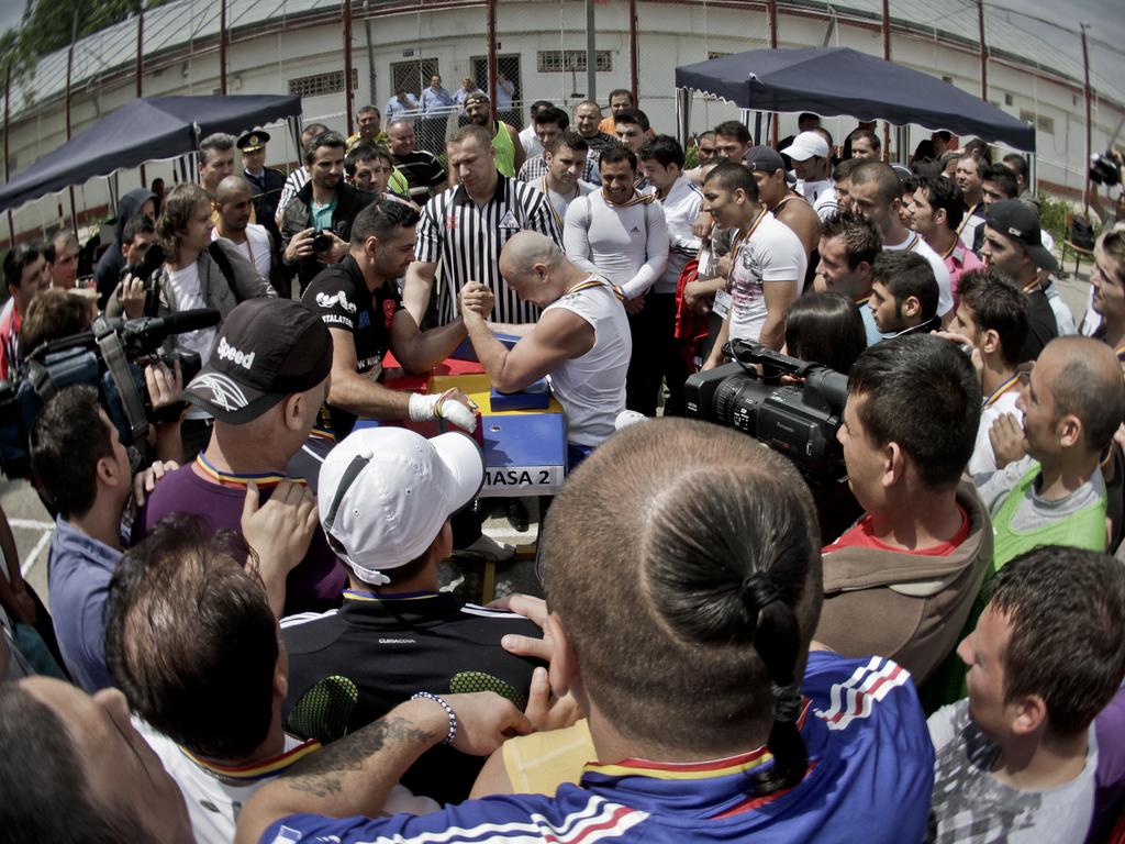 Inmates at Romania’s Jilava watch an arm wrestling match. Picture: Vadim Ghirda/AP