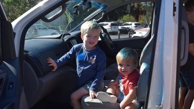 Cooper and Logan in the front of the police car