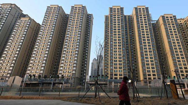 A woman walks past a complex in Beijing by China’s deeply indebted Evergrande Group. Picture: Greg Baker/ AFP