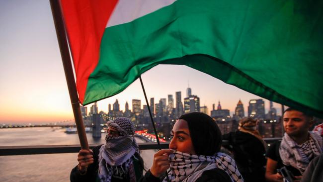 Demonstrators hold Palestinian flags as they march over the Brooklyn Bridge during a rally in New York City on November 7. Picture: AFP